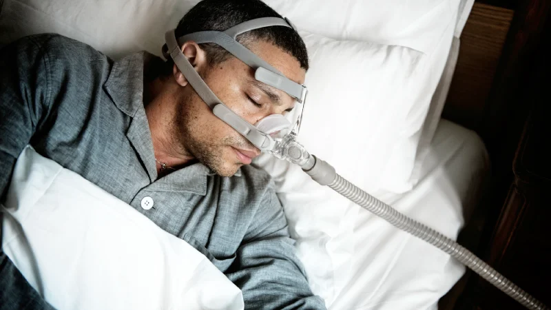 uyku apnesi cpap solunum cihazına bağlı uyuyan adam