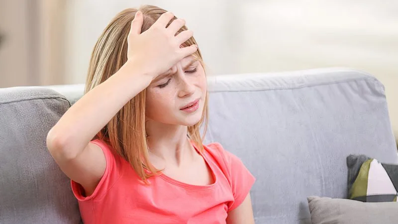 menenjit nedeniyle baş ağrısı çeken kız çocuk