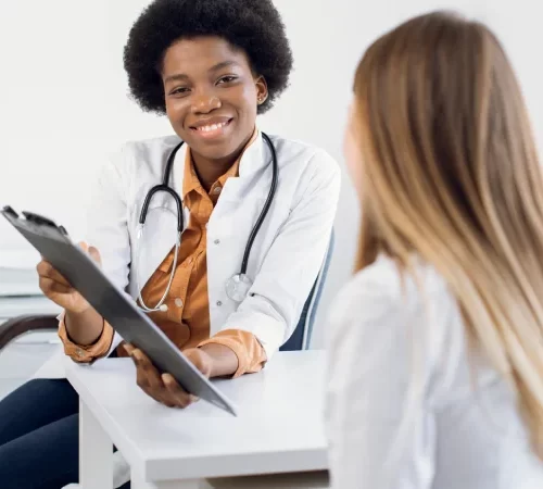 geniz eti ameliyatı riskleri hakkında bilgi veren doktor ve kadın hasta