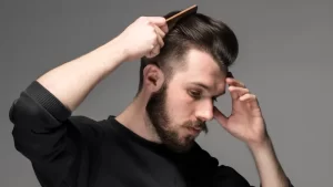 saç ekiminden sonra saç boyama işlemi için saçlarını tarayan erkek