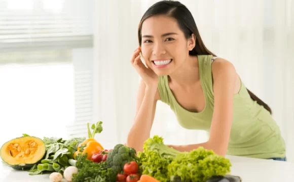 Ödem Söktürücü Besinler - sağlıklı besinlerin arkasında gülümseyen bir kadın