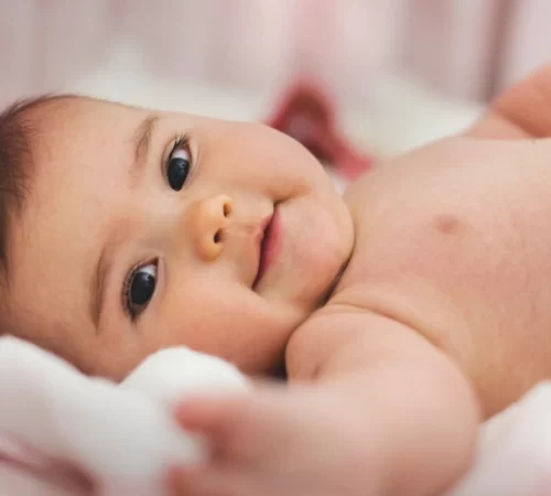 Tortikolis Hastaları İçin Fizik Tedavi Önemi- yatarak gülümseyen bebek